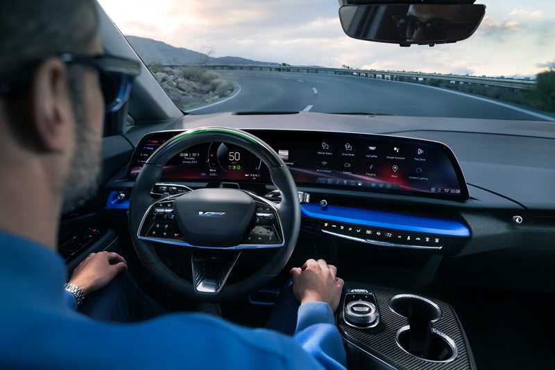 Front View of the 2026 OPTIQ-V Driving Through the Dusk Utilizing its Headlights | Faulkner Cadillac Trevose in TREVOSE PA