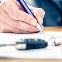 person with pen signing papers