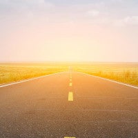 long road with sun setting