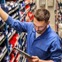 service technician searching for parts on shelf