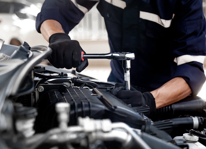 mechanic using wrench to fix car engine