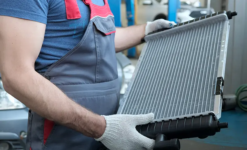 technician holding a new car radiator