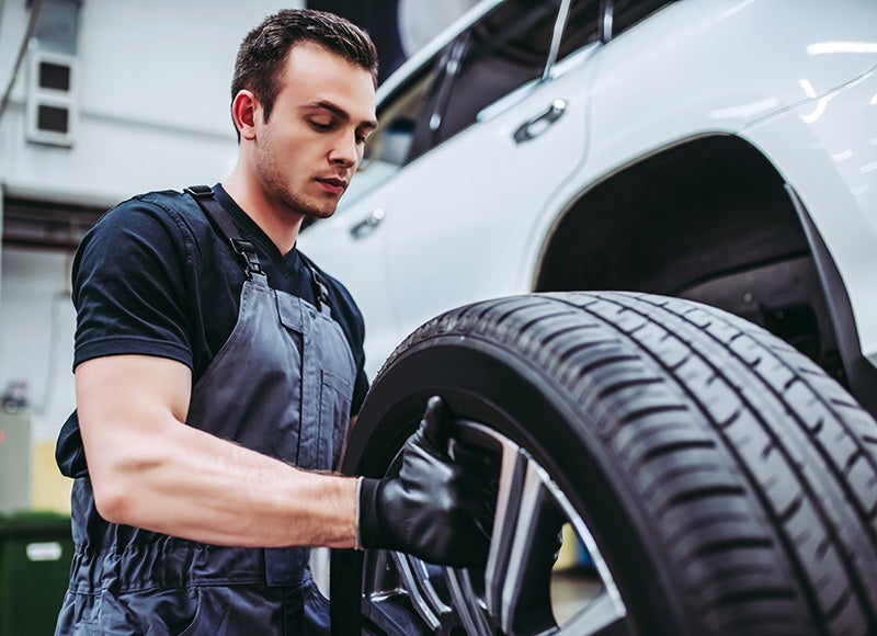 mechanic putting new tire on car