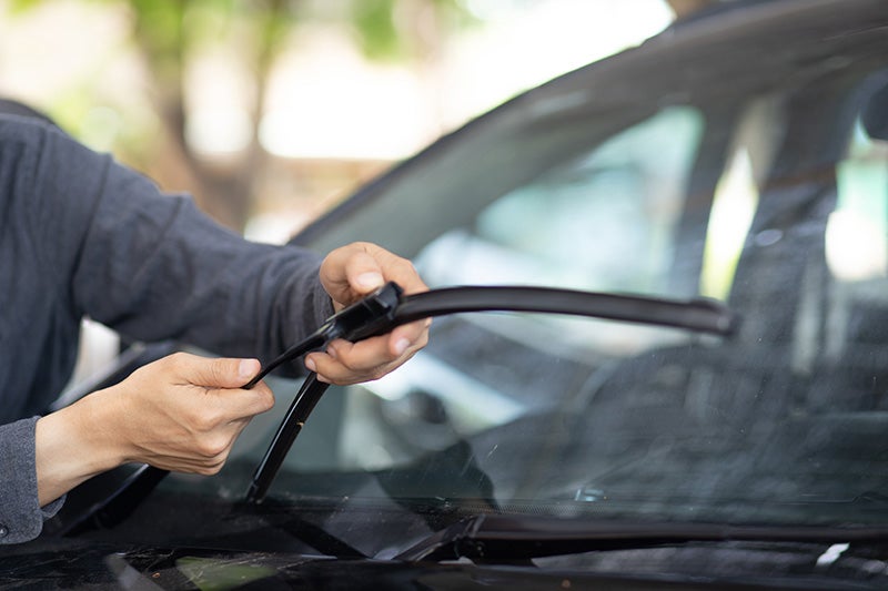 mechanic putting on new wind shield wiper blade